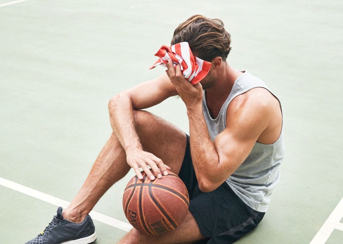 Person wiping sweat playing basketball